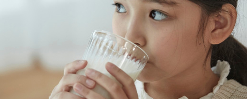 Jeune fille qui boit un verre de lait